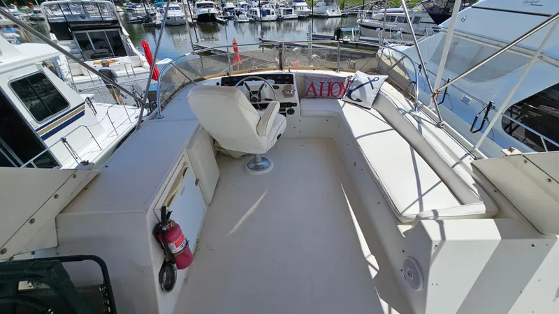 Slide: The Image of 1988 Bluewater Yachts 55 Coastal Cruiser helm with seating, docked at marina. - 8