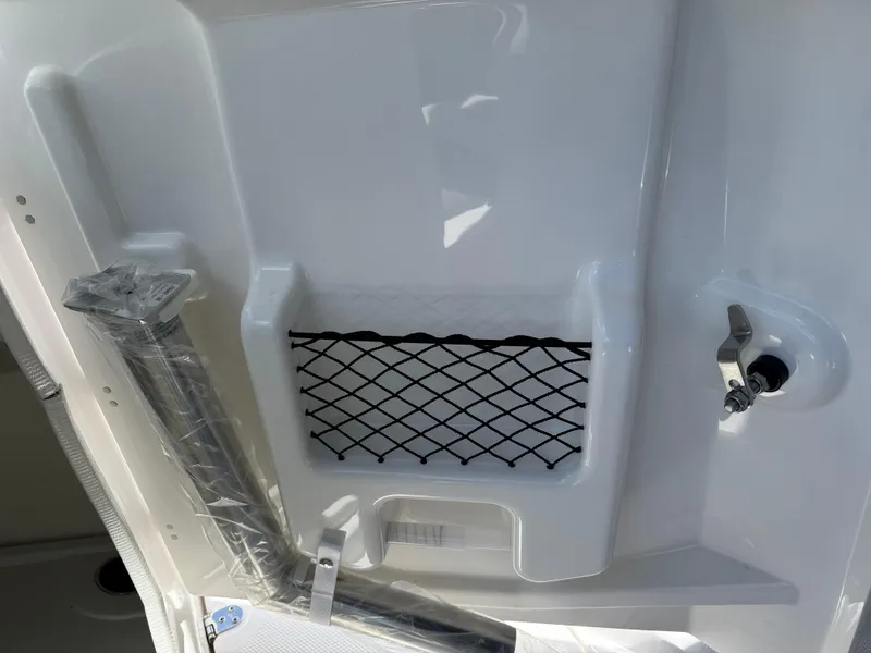 Slide: The Image of 2025 Yamaha AR250 boat interior with storage net and latch detail. - 16