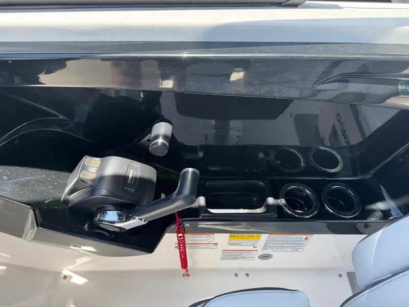 Slide: The Image of 2025 Yamaha AR250 boat control panel with throttle and cup holders. - 22