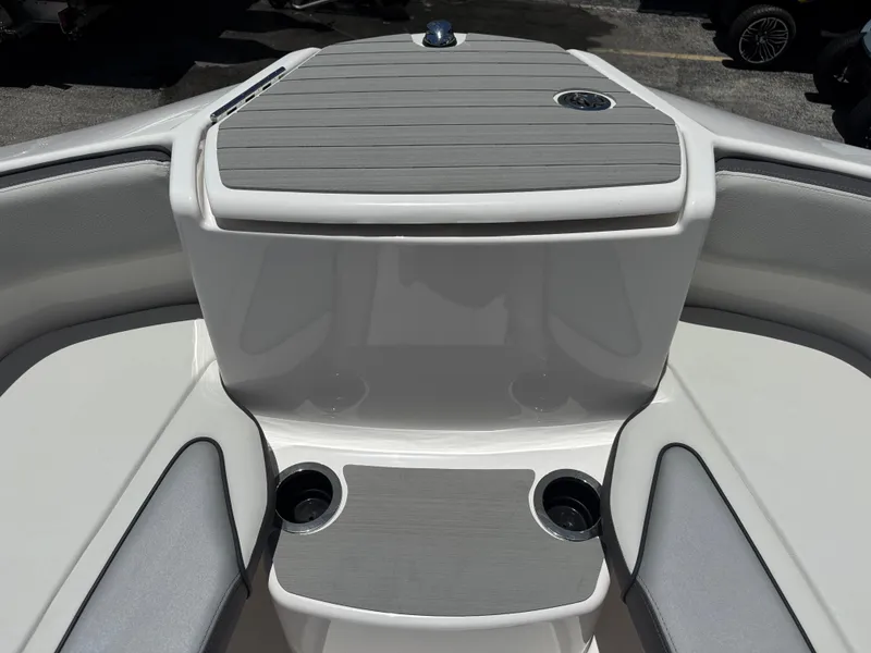Slide: The Image of 2025 Yamaha Boats AR250 bow seating area with cup holders and storage. - 6