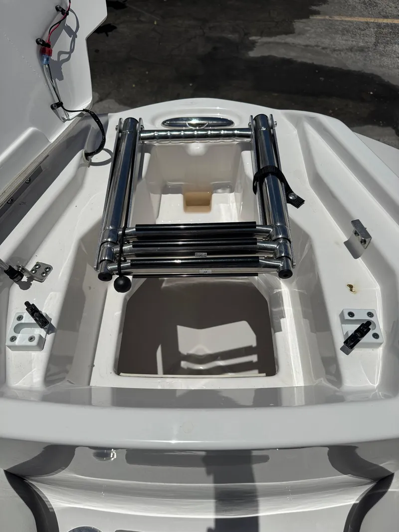 Slide: The Image of 2025 Yamaha Boats AR250 ladder compartment with stainless steel ladder and white interior. - 7