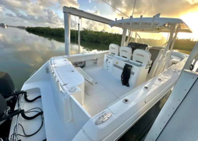 Slide: The Image of 2017 Stamas 390 Tarpon boat interior with helm, seats, and fishing rod holders at sunset. - 12