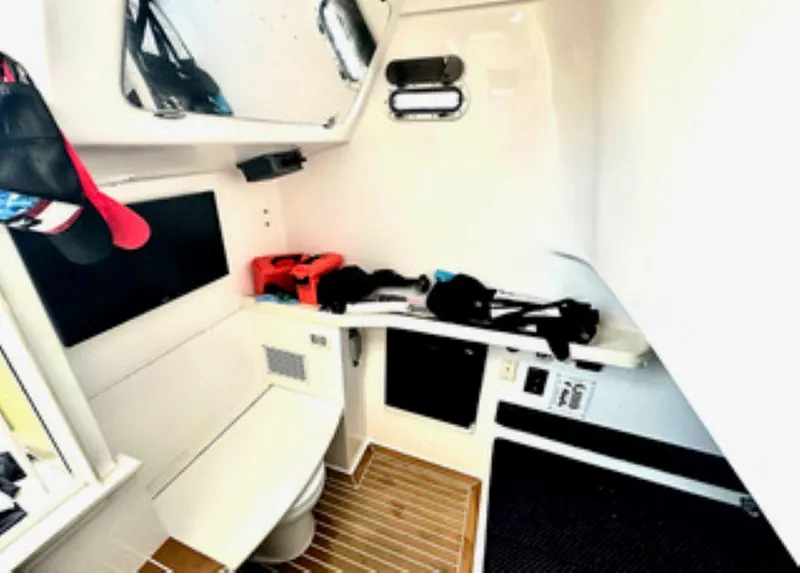 Slide: The Image of 2017 Stamas 390 Tarpon boat interior with helm, seating, and fishing rod holders at dock. - 17