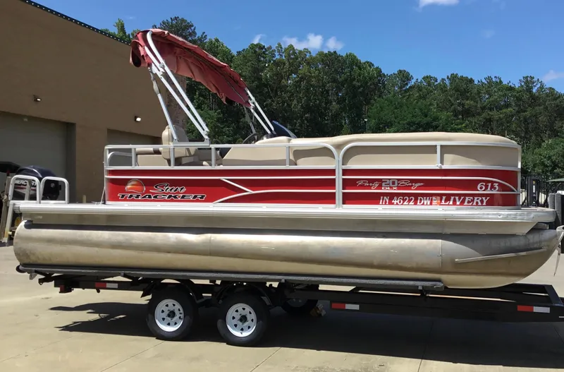 Slide: The Image of 2016 Sun Tracker Party Barge 20 DLX pontoon boat on trailer, red and beige design. - 2