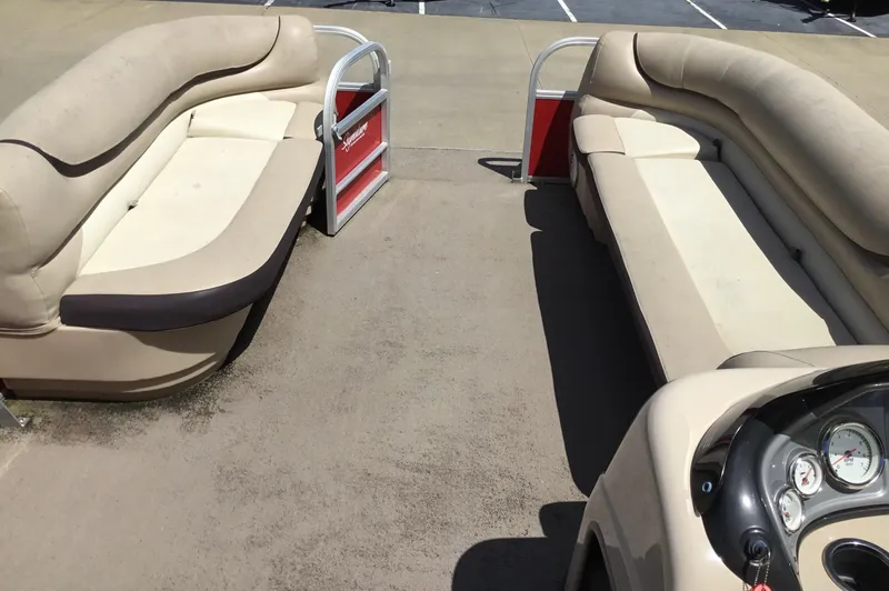 Slide: The Image of 2016 Sun Tracker Party Barge 20 DLX interior with beige seating and control panel. - 4