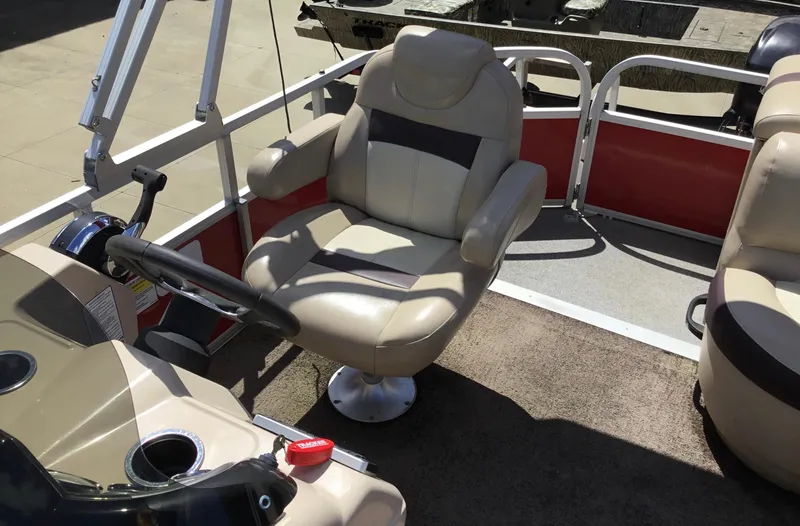 Slide: The Image of 2016 Sun Tracker Party Barge 20 DLX interior with captain's chair and steering console. - 6