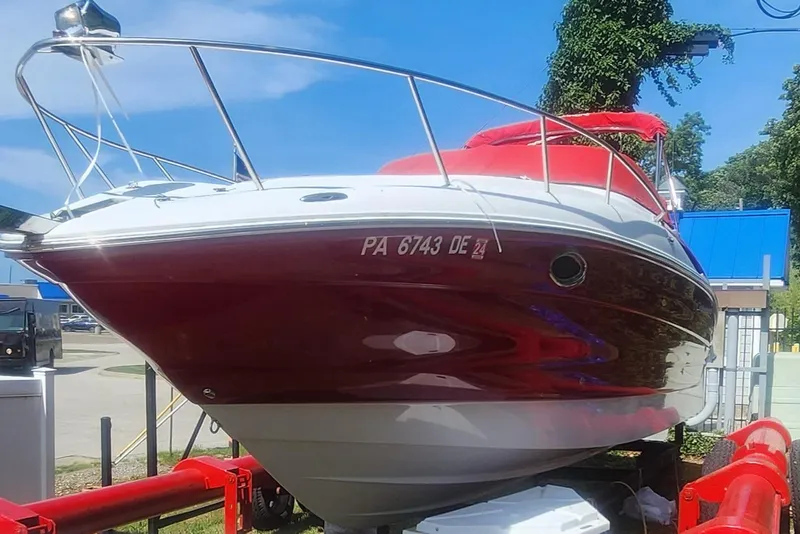 The Image of 2009 Crownline 250cr boat with red and white exterior on a trailer. - 0