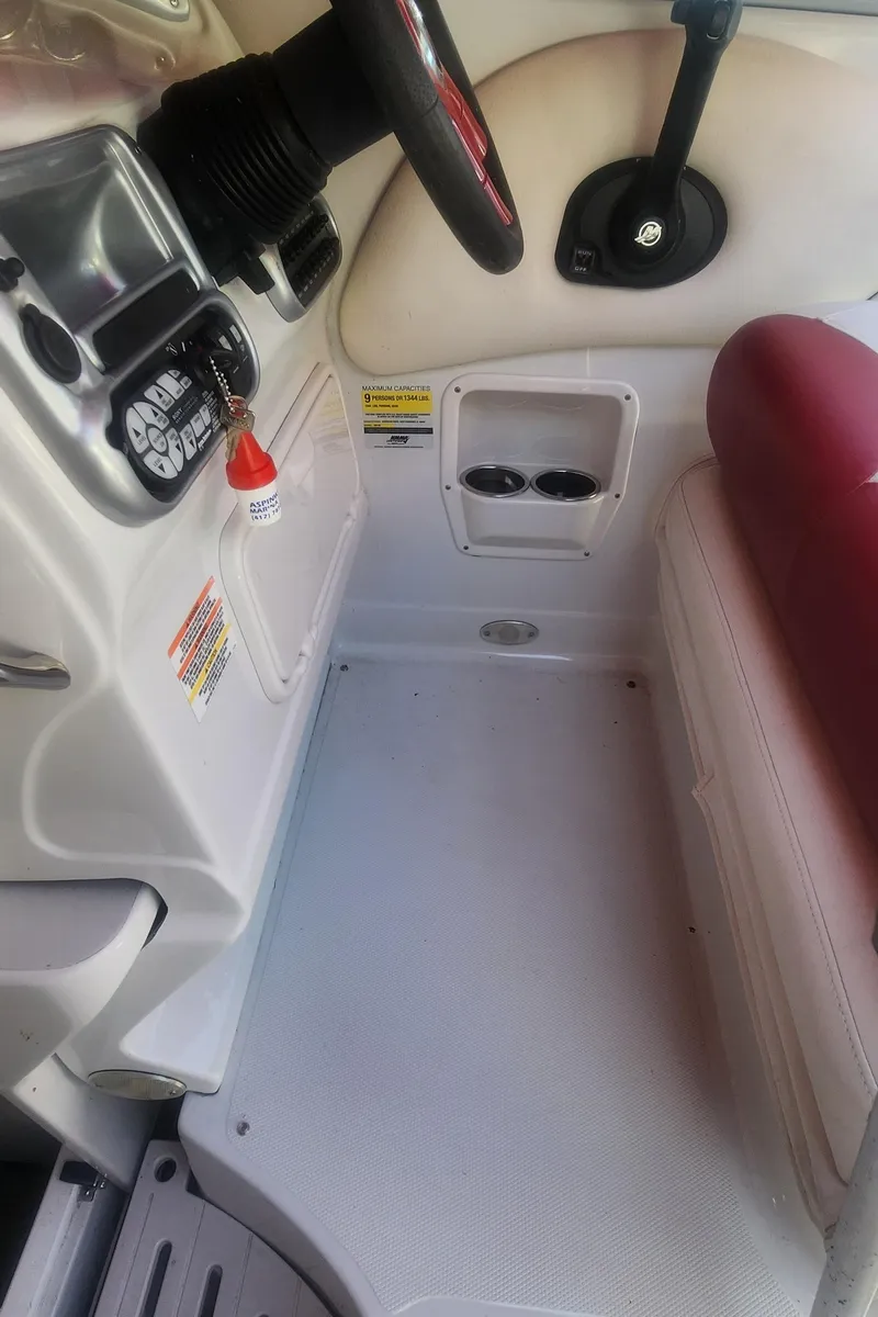 Slide: The Image of 2009 Crownline 250CR boat interior with steering wheel and seating area. - 13