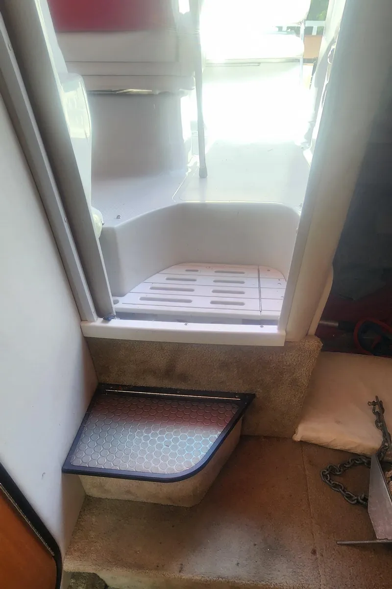 Slide: The Image of Interior view of a 2009 Crownline 250cr boat, featuring a step and seating area. - 18