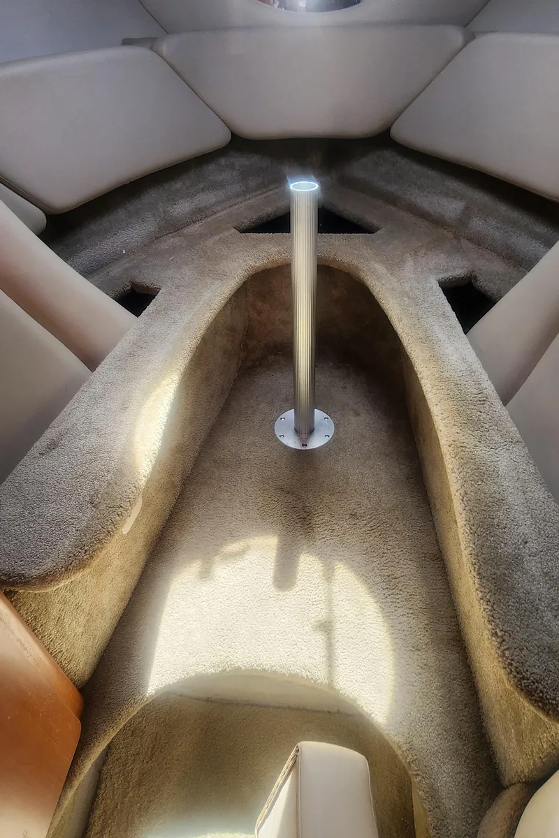 Slide: The Image of Interior cabin of a 2009 Crownline 250cr boat, featuring plush seating and a central pole. - 20