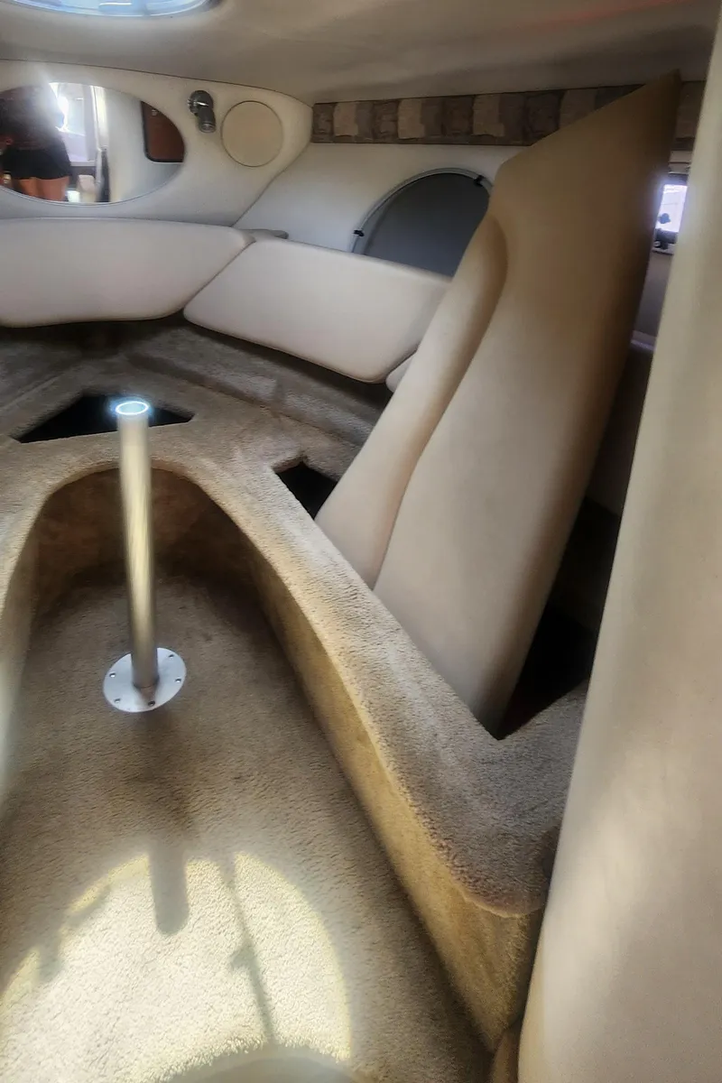 Slide: The Image of Interior cabin of a 2009 Crownline 250cr boat, featuring beige upholstery and seating. - 22
