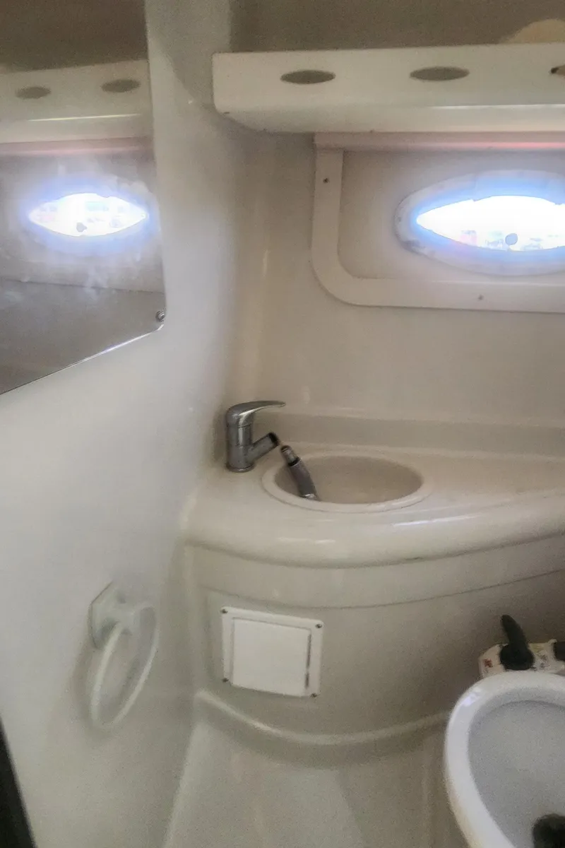 Slide: The Image of 2009 Crownline 250cr boat bathroom with sink, faucet, and porthole window. - 26