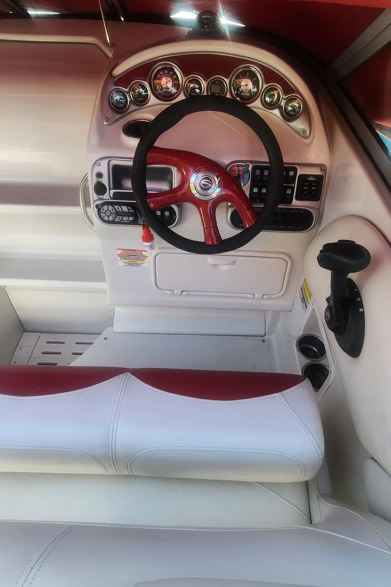 Slide: The Image of 2009 Crownline 250CR boat dashboard with red steering wheel and instrument panel. - 6