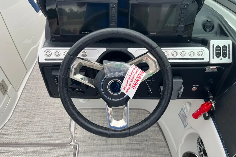 Slide: The Image of Steering wheel and dashboard of 2026 Crownline 270 SS boat with navigation controls. - 12