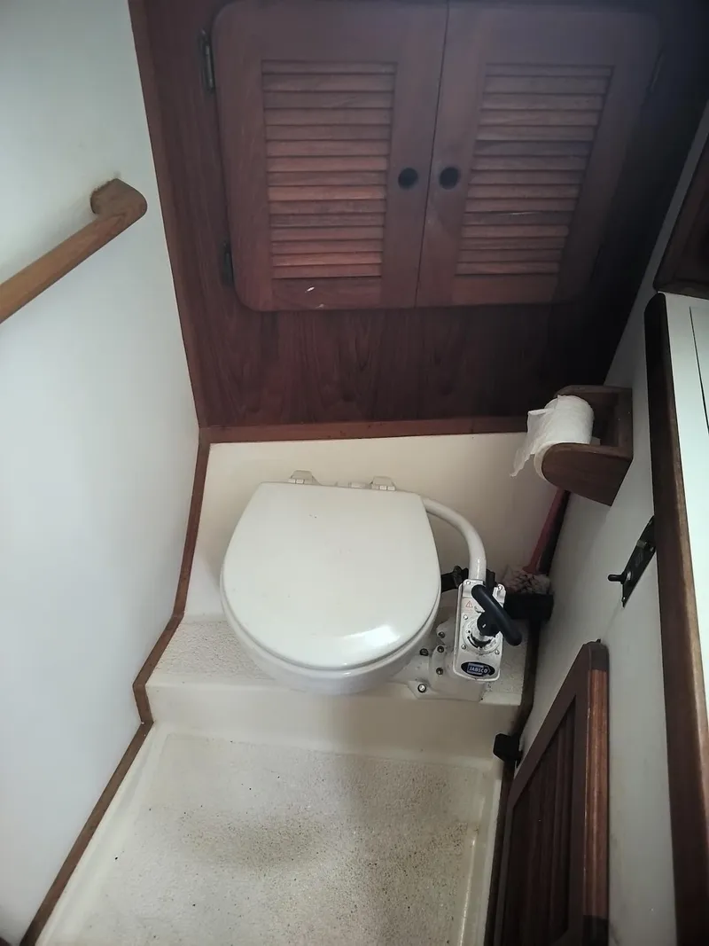 Slide: The Image of 1983 Morgan 32-3 boat bathroom with toilet and wooden cabinetry. - 10