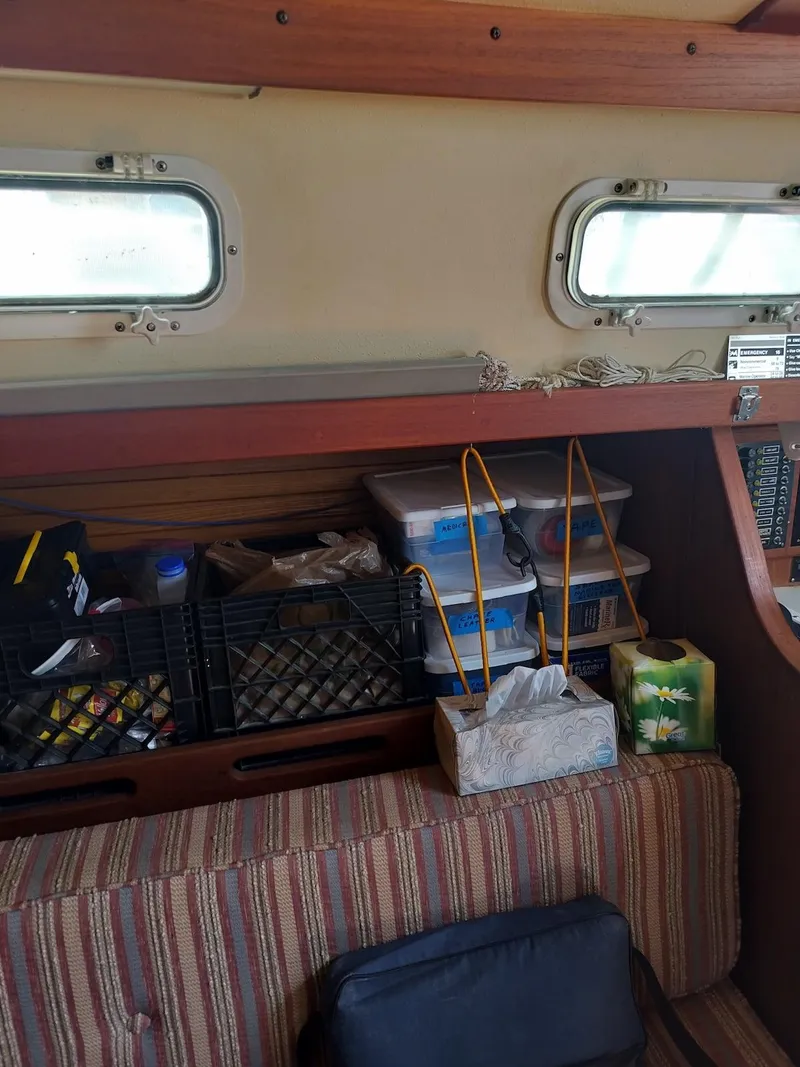 Slide: The Image of Interior of 1983 Morgan 32-3 sailboat with organized storage and striped seating. - 12