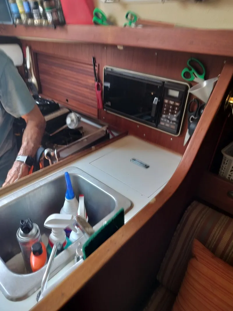 Slide: The Image of 1983 Morgan 32-3 yacht interior with kitchen sink, microwave, and storage. - 13