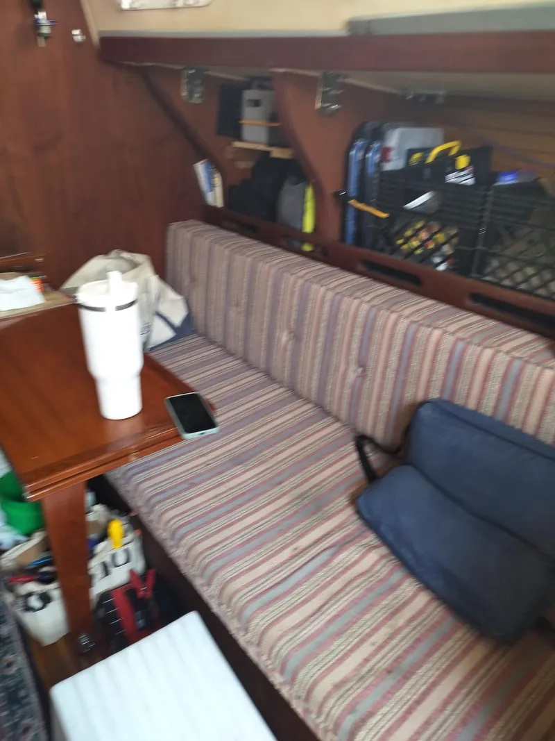 Slide: The Image of Interior of a 1983 Morgan 32-3 sailboat with striped seating and wooden table. - 14