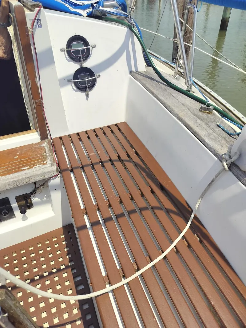 Slide: The Image of 1983 Morgan 32-3 sailboat cockpit with wooden slatted flooring and nautical instruments. - 17