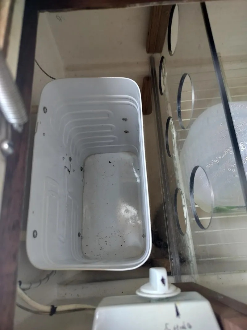 Slide: The Image of Empty white container inside a glass enclosure with circular vents. - 19