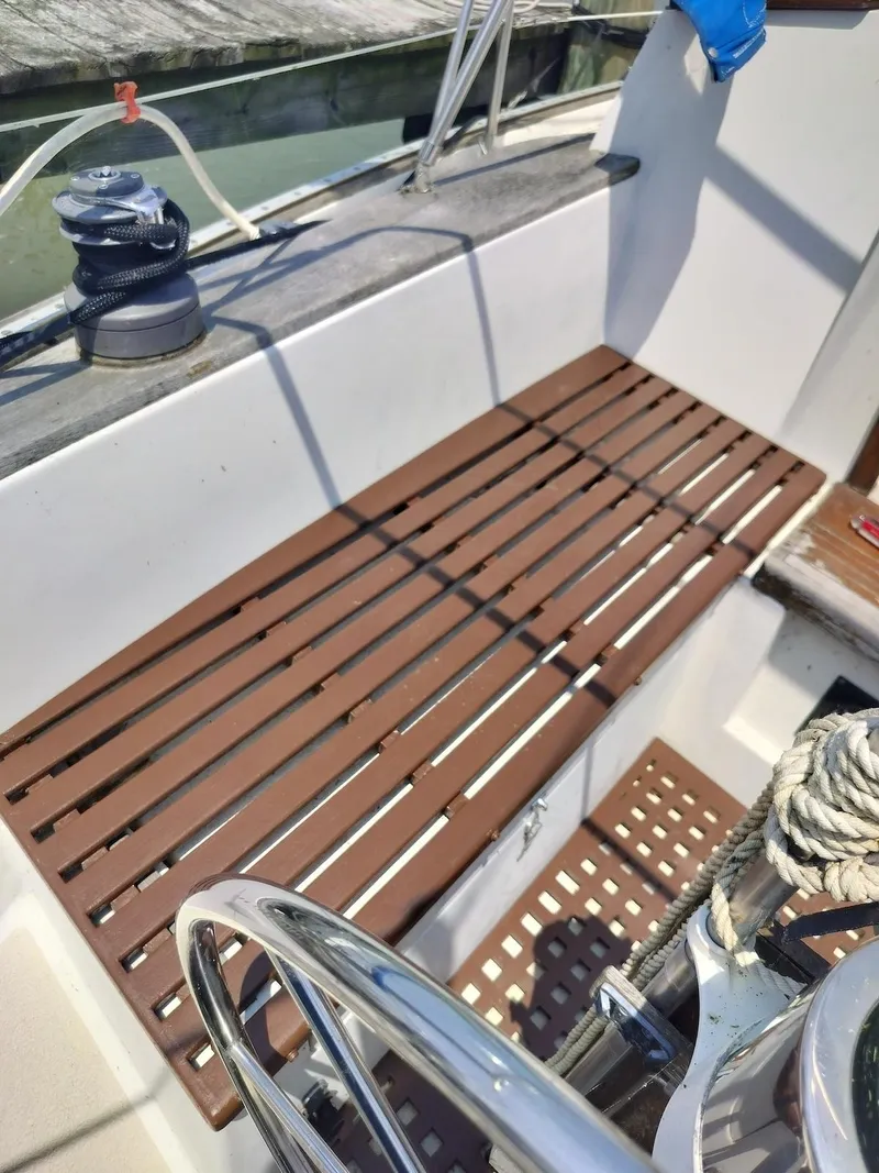 Slide: The Image of 1983 Morgan 32-3 sailboat cockpit with wooden slatted seating and steering wheel. - 5