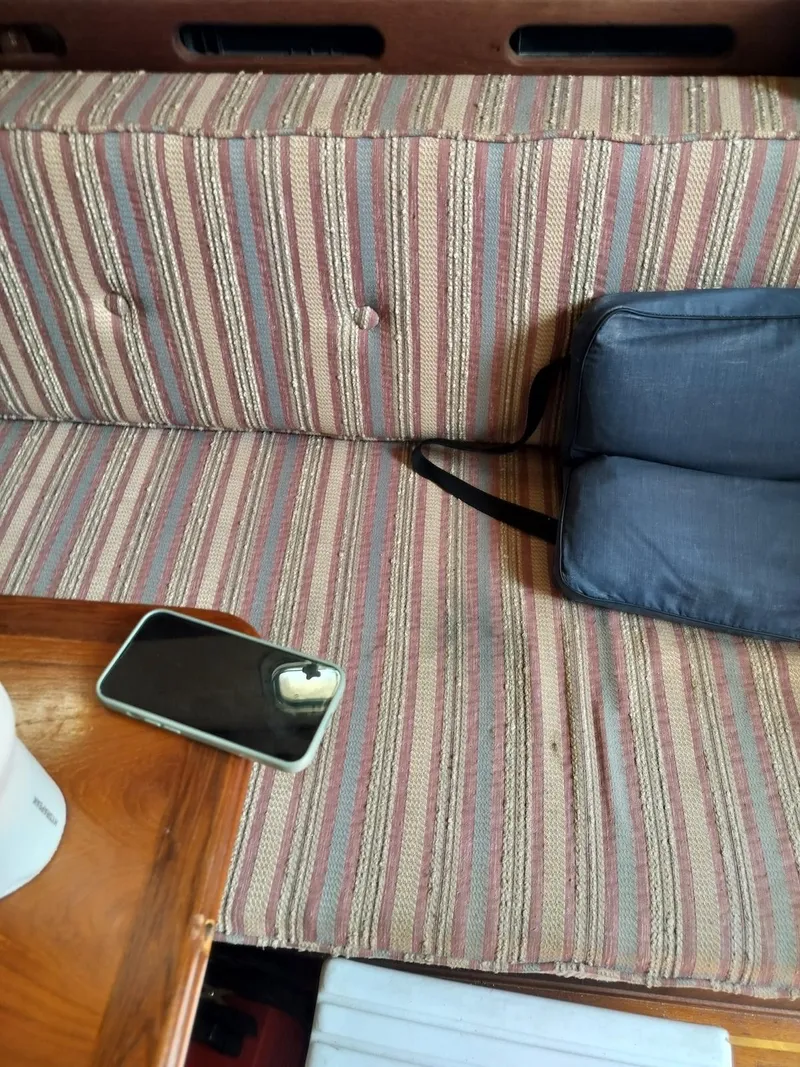 Slide: The Image of Striped boat seat with a phone and bag, Morgan 32-3, 1983. - 7