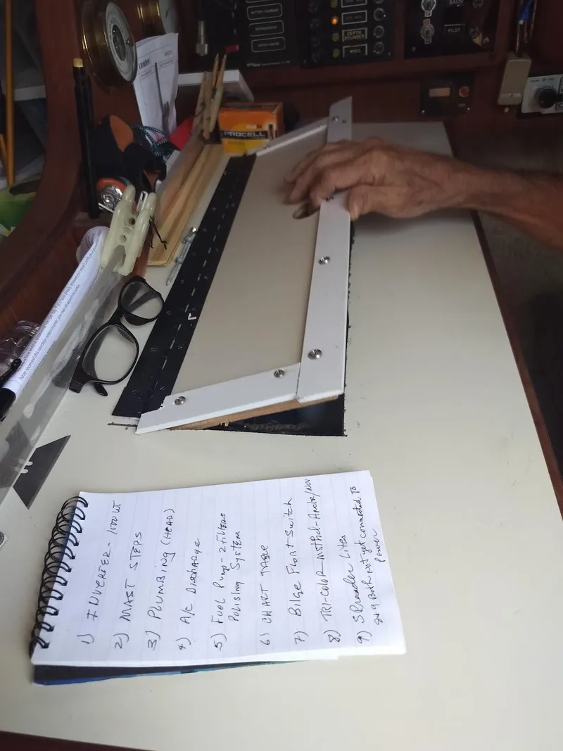 Slide: The Image of Hands working on a navigation chart inside a 1983 Morgan 32-3 sailboat. - 8