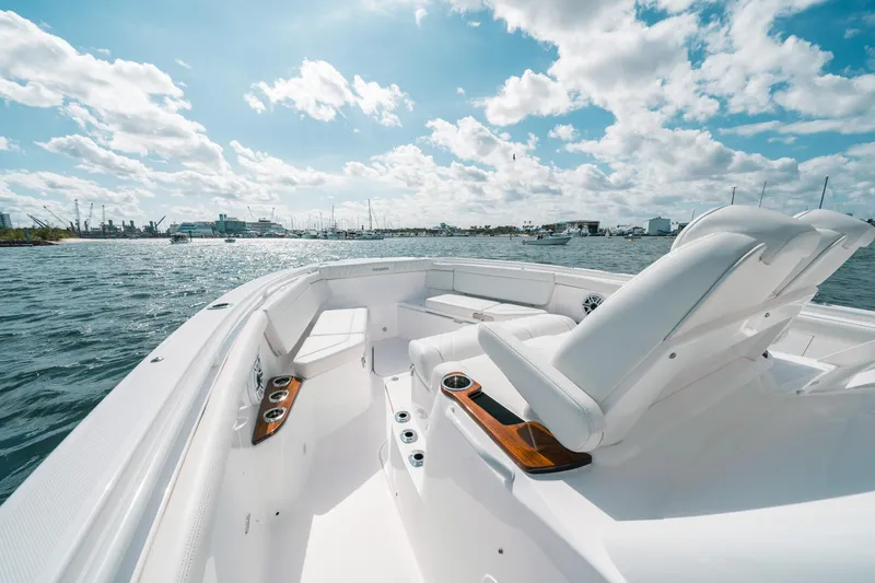 Slide: The Image of 2022 Everglades 395cc boat on water, featuring sleek white seating and clear skies. - 18