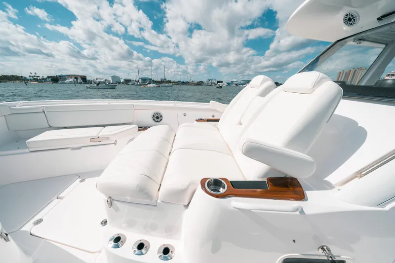 Slide: The Image of Luxurious seating on 2022 Everglades 395cc boat, featuring white upholstery and cup holders. - 19