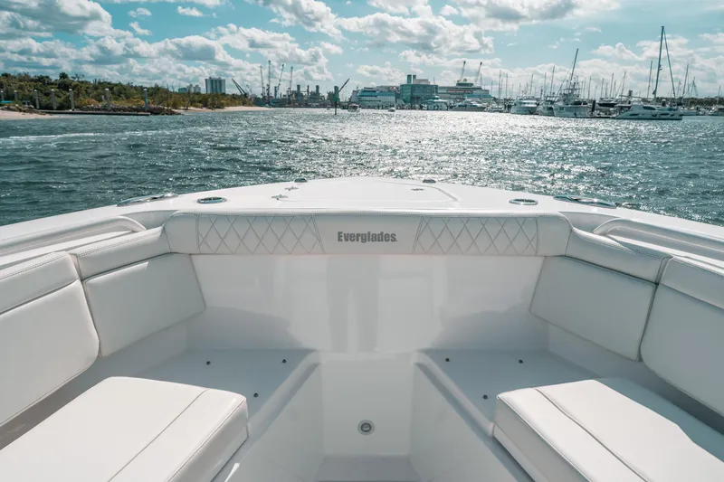 Slide: The Image of Bow view of 2022 Everglades 395cc boat on water, sunny day, marina in background. - 23