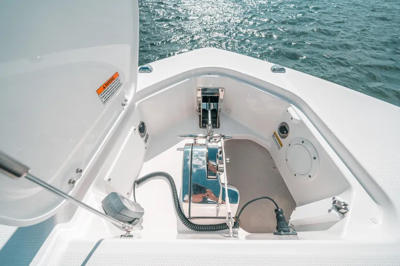 Slide: The Image of 2022 Everglades 395cc boat anchor compartment with open hatch, on calm water. - 25