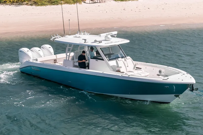 Slide: The Image of 2022 Everglades 395cc boat cruising near sandy beach, featuring triple outboard engines. - 3