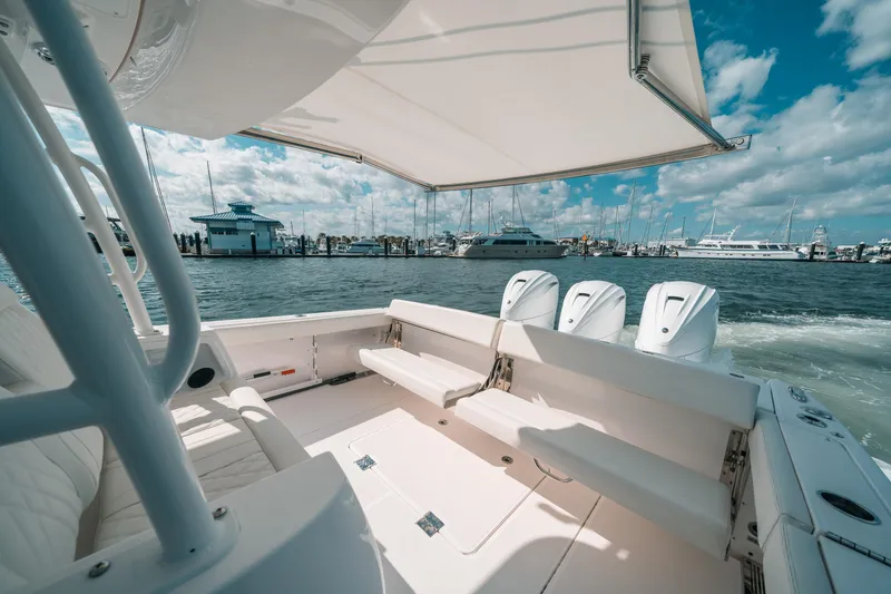 Slide: The Image of 2022 Everglades 395cc boat with triple engines, docked at a marina under a sunny sky. - 33