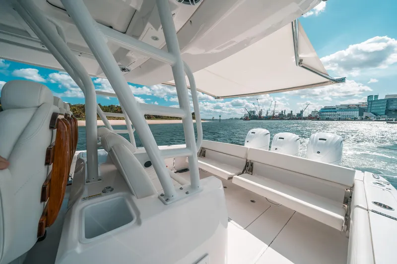 Slide: The Image of 2022 Everglades 395cc boat interior with seating, ocean view, and clear skies. - 34