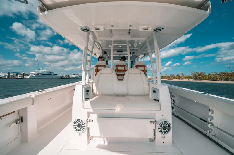 Slide: The Image of 2022 Everglades 395cc boat interior with seating, ocean view, and clear sky. - 40