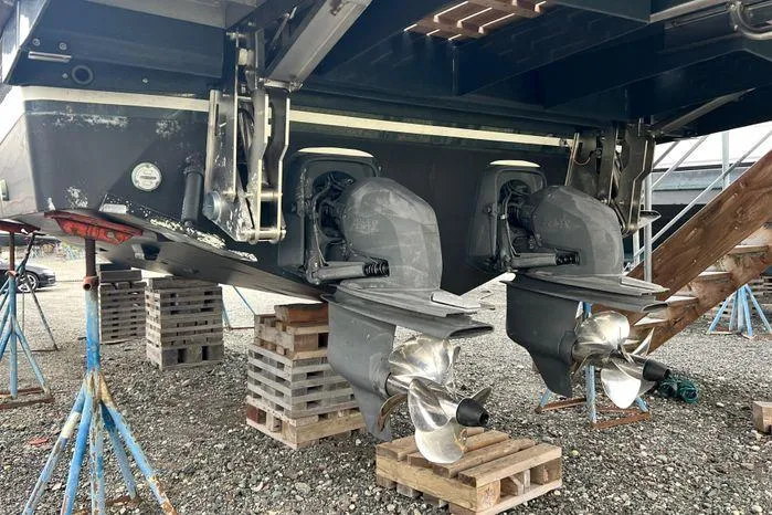 Slide: The Image of 2024 Sargo 36 boat with dual propellers on dry dock, supported by wooden blocks. - 17