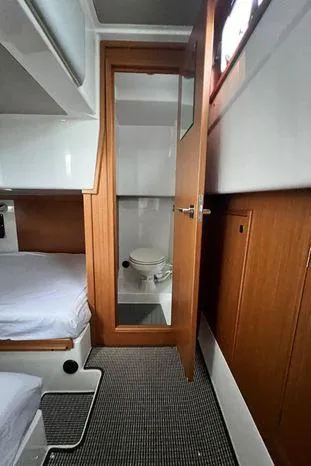 Slide: The Image of 2024 Sargo 36 cabin interior with bed and bathroom, featuring wooden accents and modern design. - 27