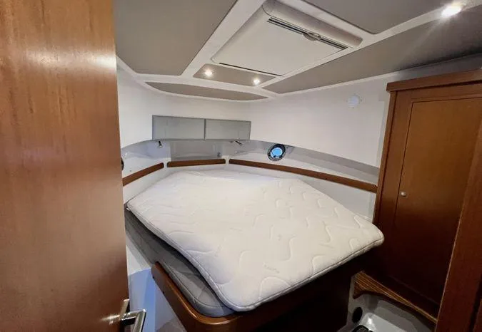 Slide: The Image of 2024 Sargo 36 cabin interior with bed, wooden cabinetry, and ceiling lights. - 32