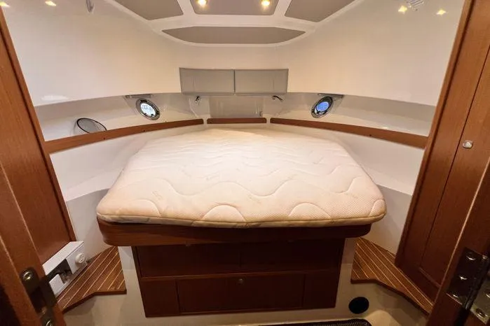 Slide: The Image of Interior cabin of 2024 Sargo 36 boat with cozy bed and wooden accents. - 36