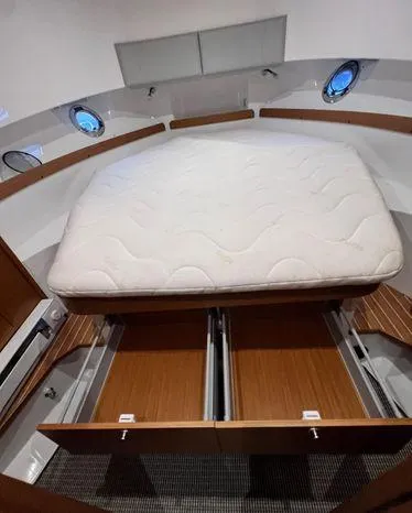 Slide: The Image of 2024 Sargo 36 interior cabin with bed and storage drawers, featuring porthole windows. - 37