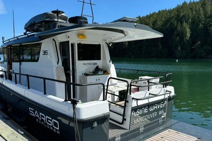 Slide: The Image of 2024 Sargo 36 boat docked on a serene lake with lush forest backdrop. - 42