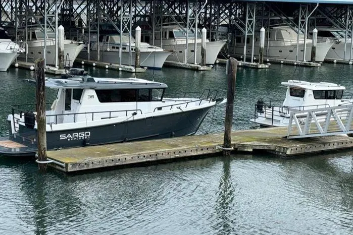 Slide: The Image of 2024 Sargo 36 boat docked at marina with other vessels in background. - 43