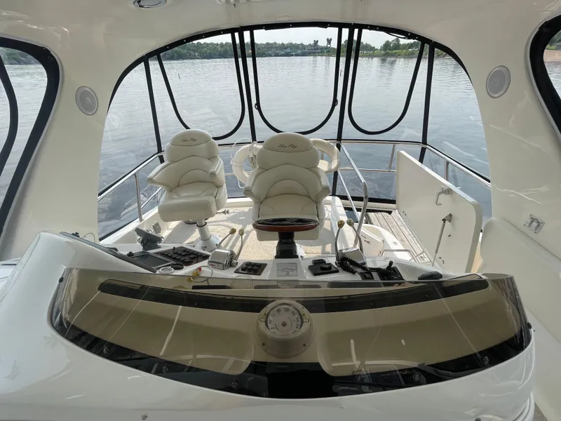 Slide: The Image of 2001 Sea Ray 480 Sedan Bridge helm with dual captain chairs and panoramic water view. - 14