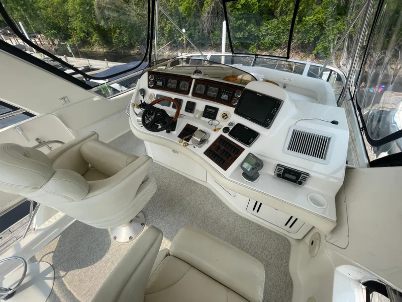 Slide: The Image of 2001 Sea Ray 480 Sedan Bridge helm with modern controls and plush seating. - 16