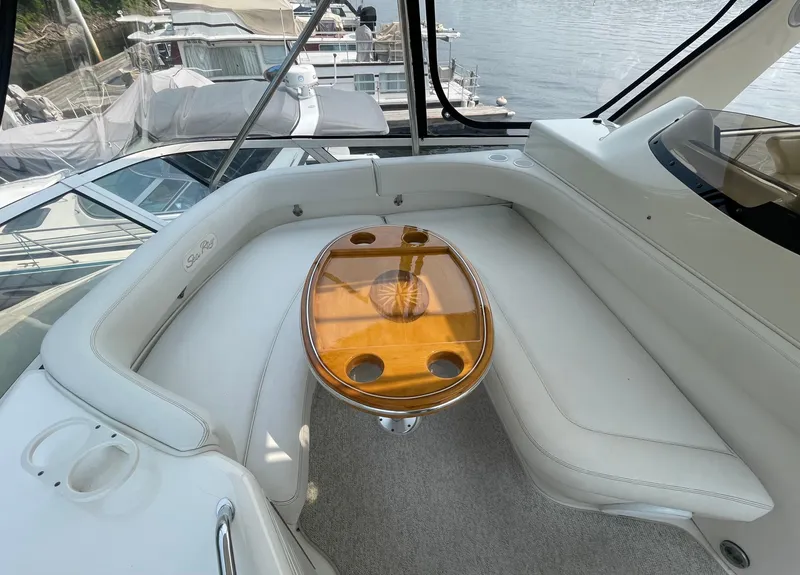 Slide: The Image of 2001 Sea Ray 480 Sedan Bridge interior with white seating and wooden table. - 21