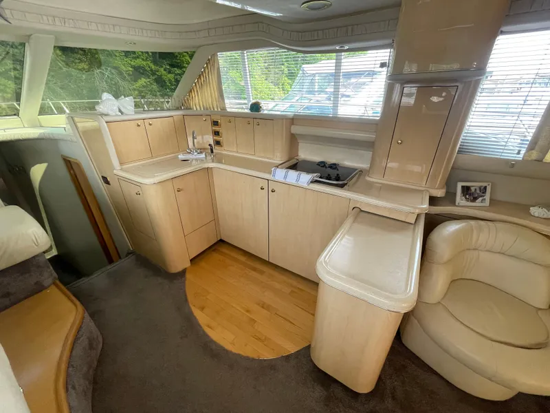 Slide: The Image of Interior of 2001 Sea Ray 480 Sedan Bridge yacht with modern kitchen and seating area. - 28