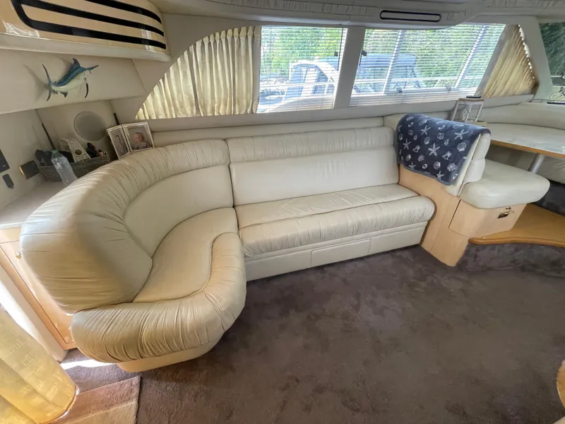 Slide: The Image of Luxurious interior of 2001 Sea Ray 480 Sedan Bridge with plush cream seating. - 31