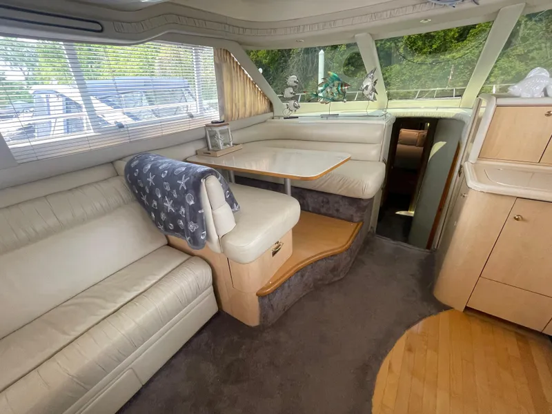 Slide: The Image of Luxurious interior of 2001 Sea Ray 480 Sedan Bridge yacht with plush seating and dining area. - 33