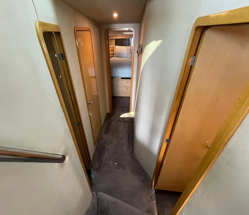 Slide: The Image of 2001 Sea Ray 480 Sedan Bridge interior hallway with wooden doors and carpeted floor. - 38