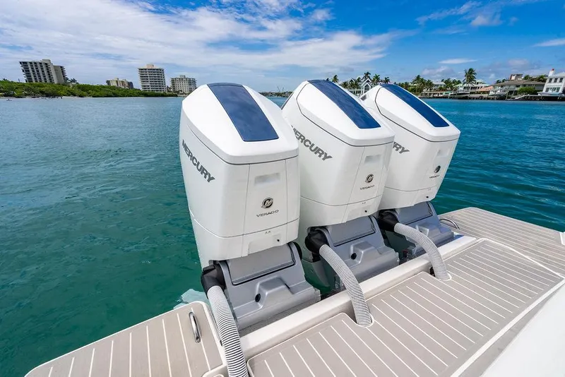 Slide: The Image of Triple Mercury outboard engines on a 2025 Tiara Yachts 48 LS, docked by a scenic waterfront. - 10